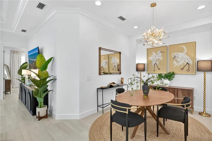 Dining room with light wood-style flooring, crown molding, recessed lighting, and a chandelier