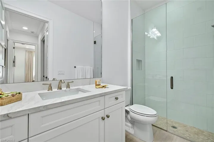 Bathroom featuring a shower stall, vanity, and light wood-style flooring