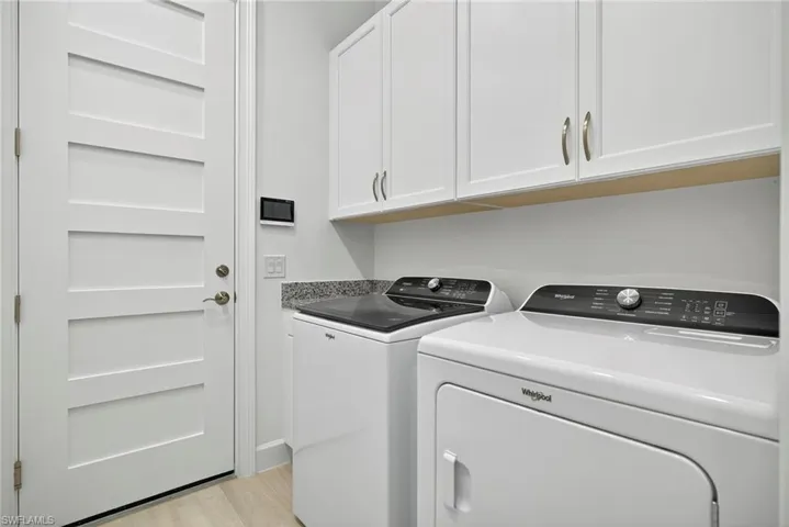 Washroom featuring cabinet space, washer and dryer, and light wood-type flooring