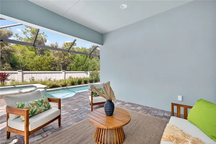 View of pool with a patio, a lanai, and a pool with connected hot tub