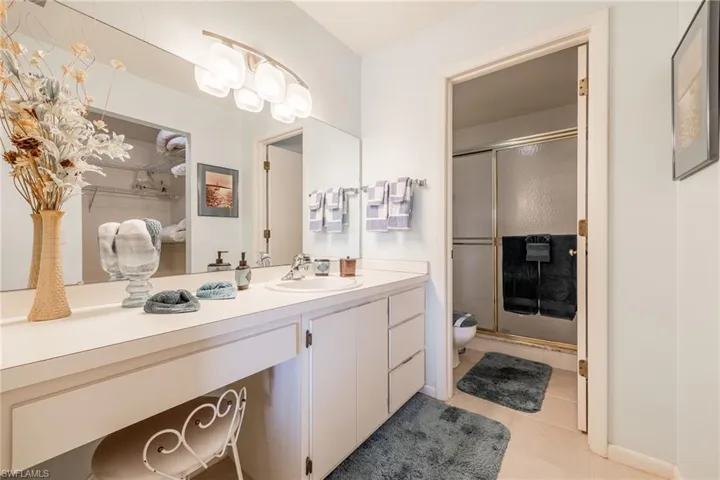Bathroom with tile patterned floors, vanity, and walk in shower