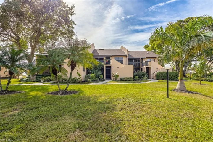 View of front of property featuring a balcony and a front lawn