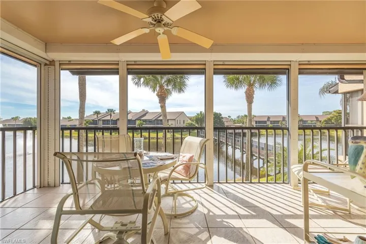Sunroom featuring ceiling fan, a water view, and a wealth of natural light