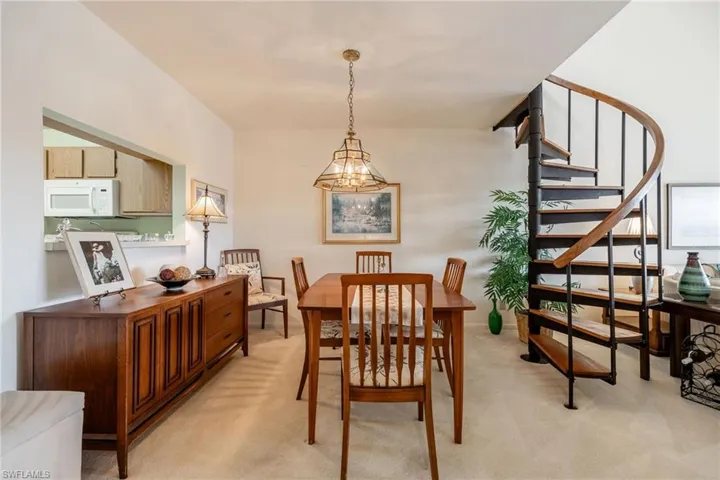 Carpeted dining area featuring an inviting chandelier