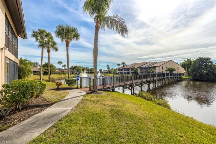 View of dock with a lawn and a water view