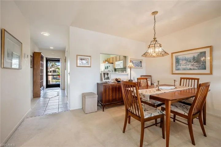 Dining room with light colored carpet and a notable chandelier