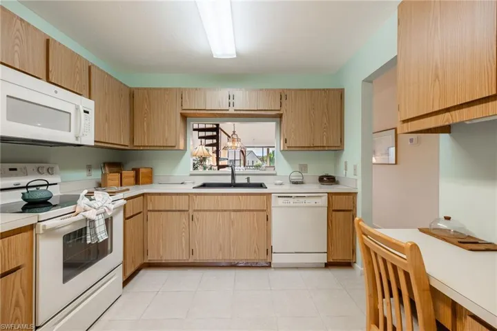 Kitchen featuring white appliances and sink