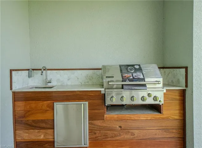 Kitchen featuring brown cabinets, light countertops, and a textured wall