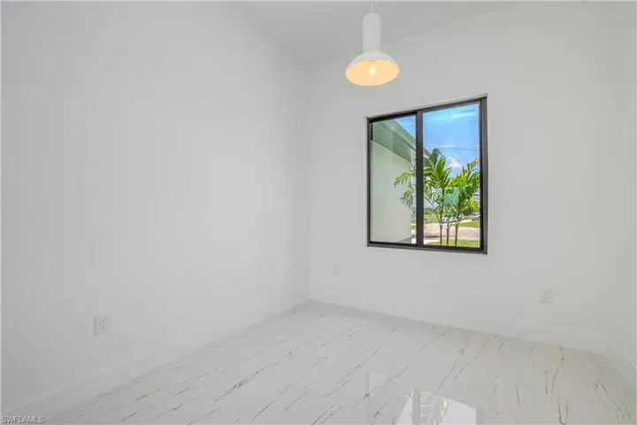 Unfurnished room featuring marble finish floors and baseboards