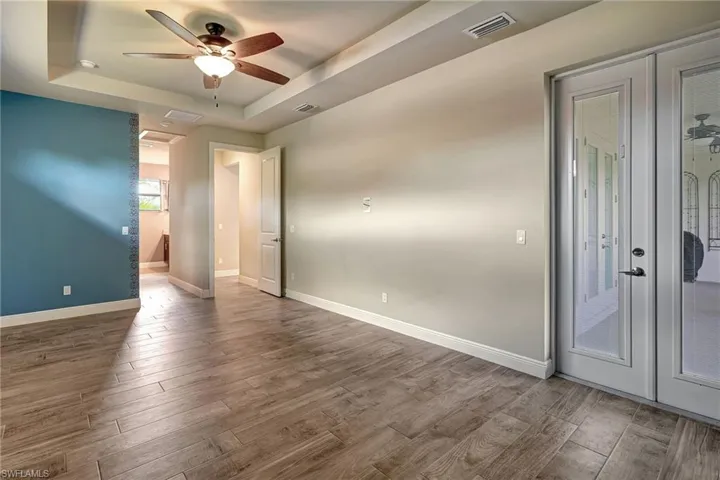 Master Bedroom featuring ceiling fan, wood plank tiled flooring, and a coffered ceiling