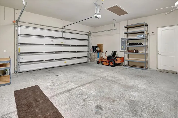 Garage featuring a garage door opener and electric panel