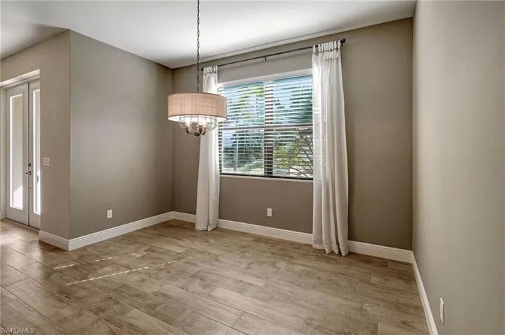 Dining area with wood plank tiled floors and large window