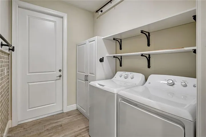 Laundry area featuring storage cabinets, extra shelving and washing machine and clothes dryer