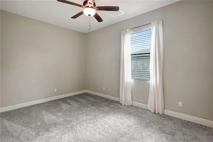 Carpeted guest bedroom with ceiling fan