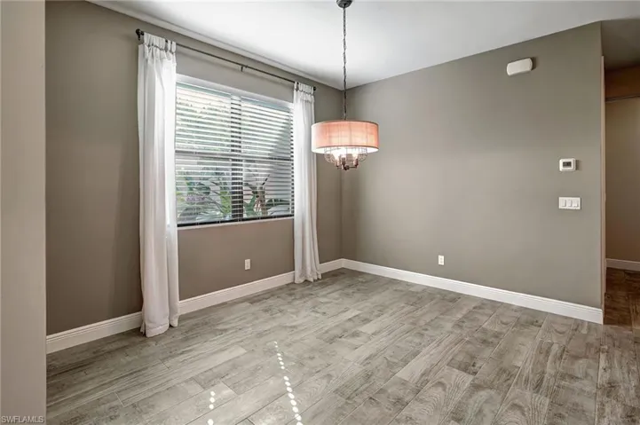 Dining room featuring light wood plank tiled flooring and a notable chandelier