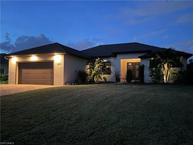 View of front of home featuring a garage and a lawn