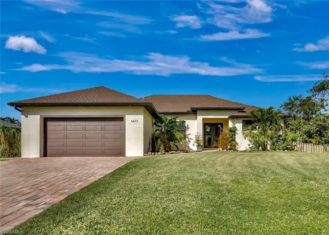 View of front facade with a garage and a front lawn