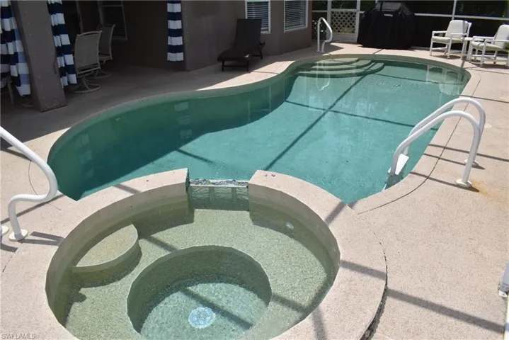 View of swimming pool with a patio area and an in ground hot tub