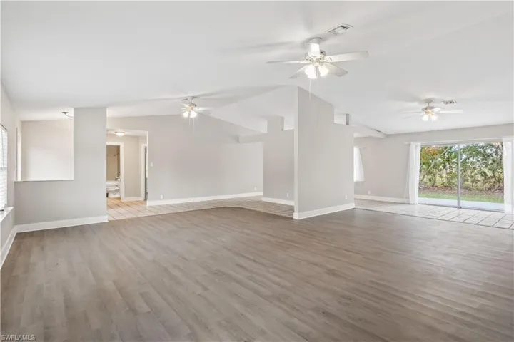 Bright and open living space featuring soaring cathedral ceilings, abundant natural light, and a seamless flow perfect for everyday living and entertaining.