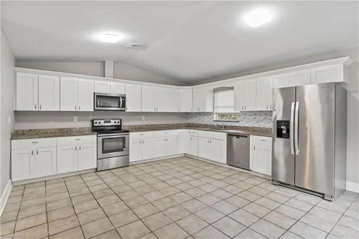 Stunning kitchen with granite countertops, stainless-steel appliances, and ample prep space—ideal for hosting family and friends.
