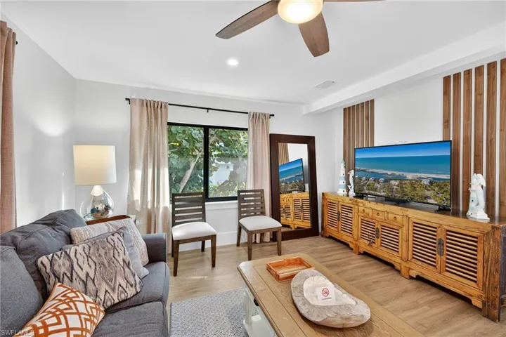 Living area featuring light wood-style floors, ceiling fan, and recessed lighting