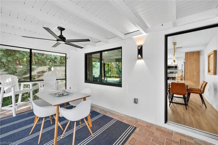 Dining area with brick floors, ceiling fan, and a wooden ceiling with exposed beams