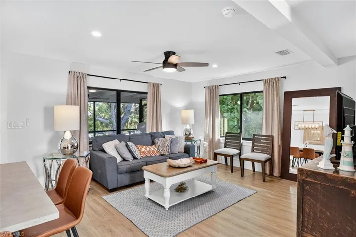 Living room featuring light wood-type flooring, a ceiling fan, and recessed lighting