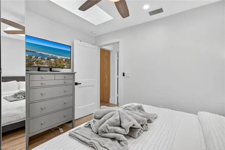 Bedroom with wood finished floors, ceiling fan, and recessed lighting