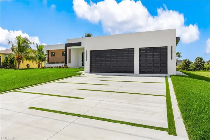 Contemporary home featuring concrete driveway, a front yard, stucco siding, and an attached garage