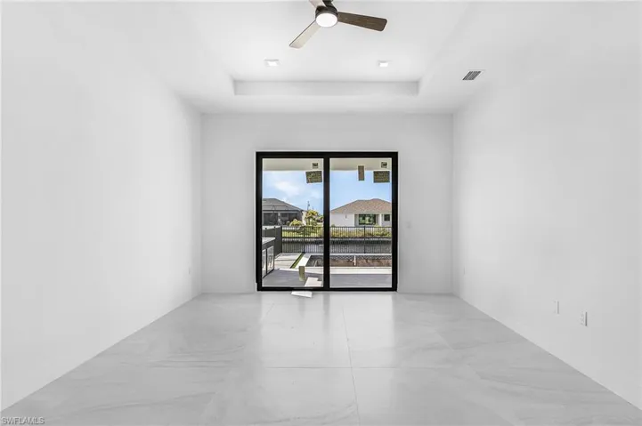 Unfurnished room featuring a raised ceiling and a ceiling fan