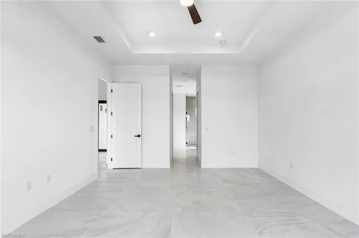 Spare room with a raised ceiling and a ceiling fan