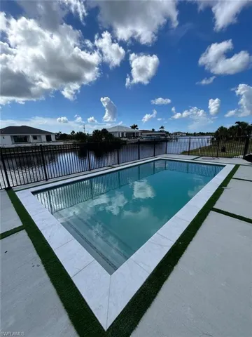 View of swimming pool featuring a water view and a patio area