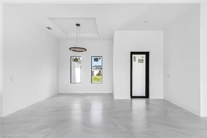 Unfurnished room featuring a raised ceiling and baseboards