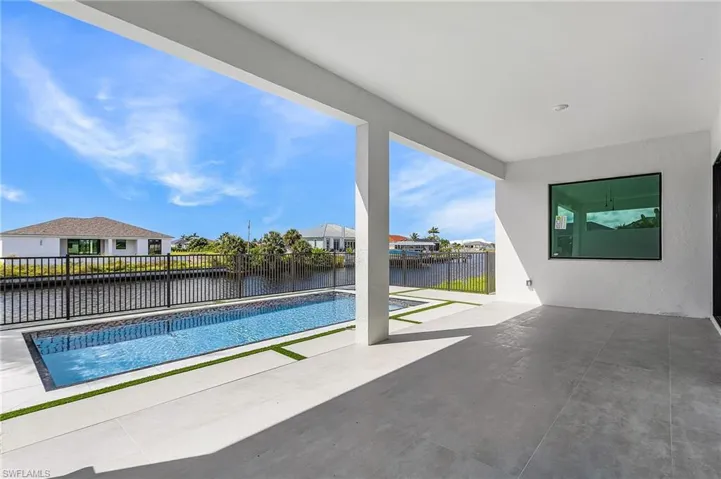 View of pool featuring a patio area, a water view, a fenced backyard, and a residential view