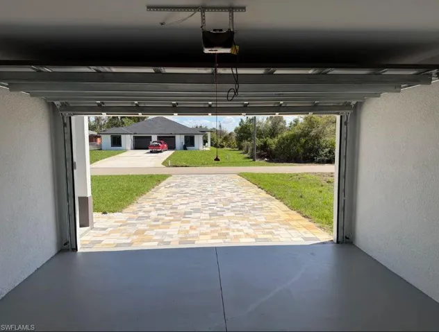 Garage featuring a textured wall and a garage door opener