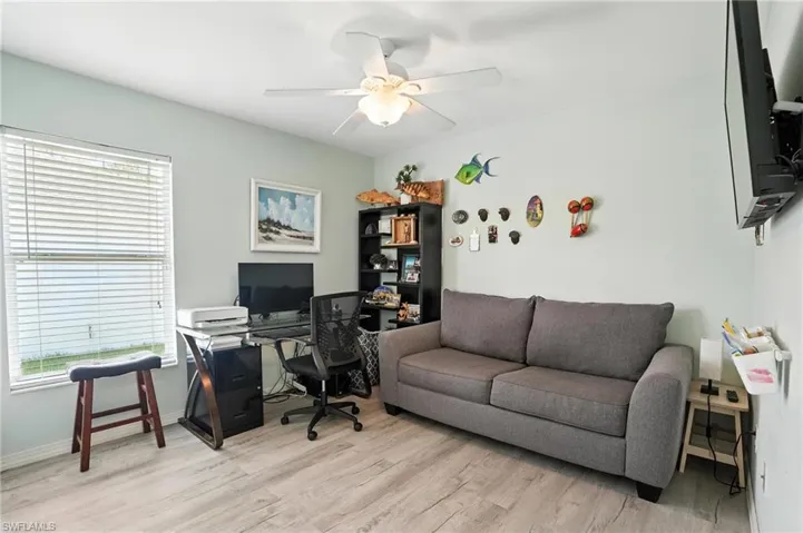 Office space with a ceiling fan, plenty of natural light, and light wood-style flooring