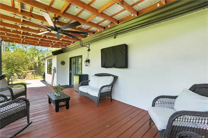 Wooden deck with an outdoor hangout area and ceiling fan