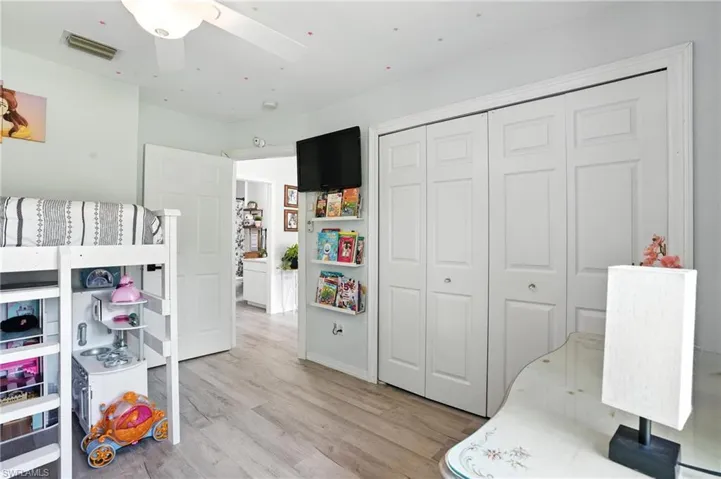 Bedroom with light wood-type flooring, a closet, and ceiling fan