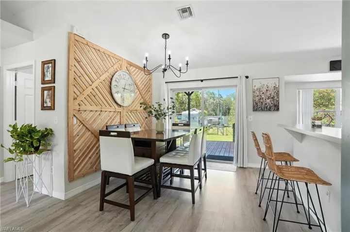 Dining space with a chandelier, light wood-style flooring, and lofted ceiling