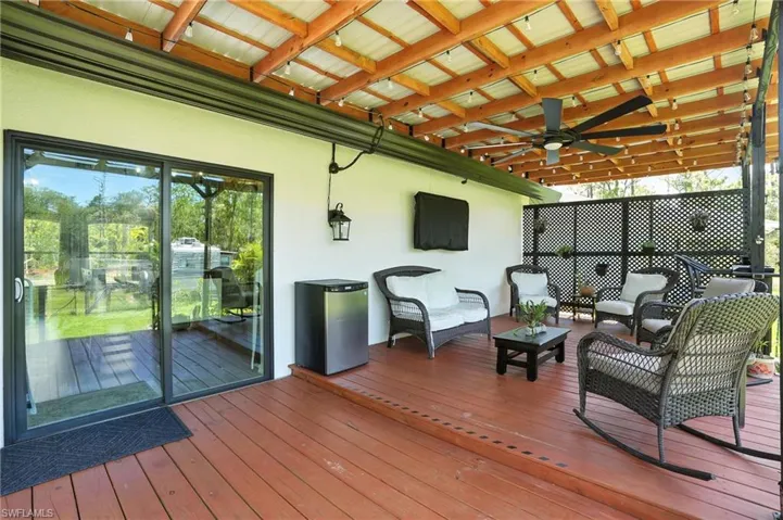 Wooden deck featuring ceiling fan and outdoor lounge area