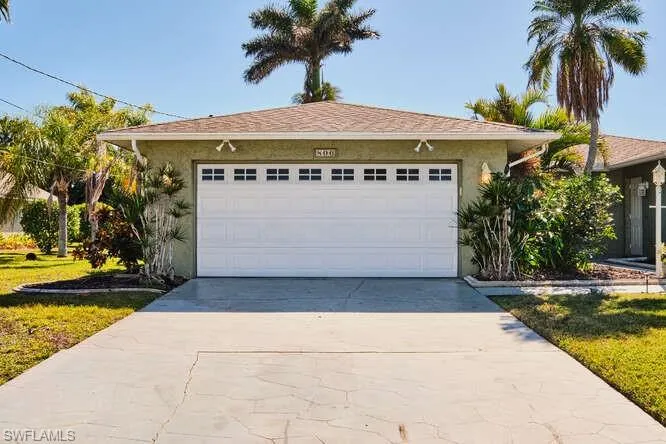 View of front of home with a garage and a front lawn