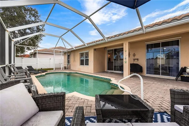 View of pool with a sunroom, a patio area, and a lanai
