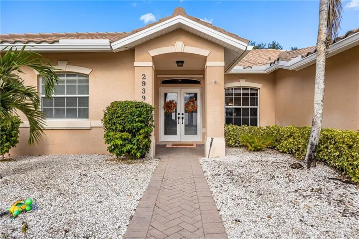 View of exterior entry featuring stucco siding, french doors, and a tiled roof
