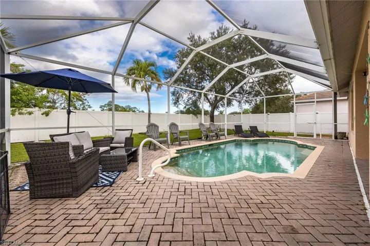 View of swimming pool featuring a lanai, a sunroom, a patio, and a fenced backyard
