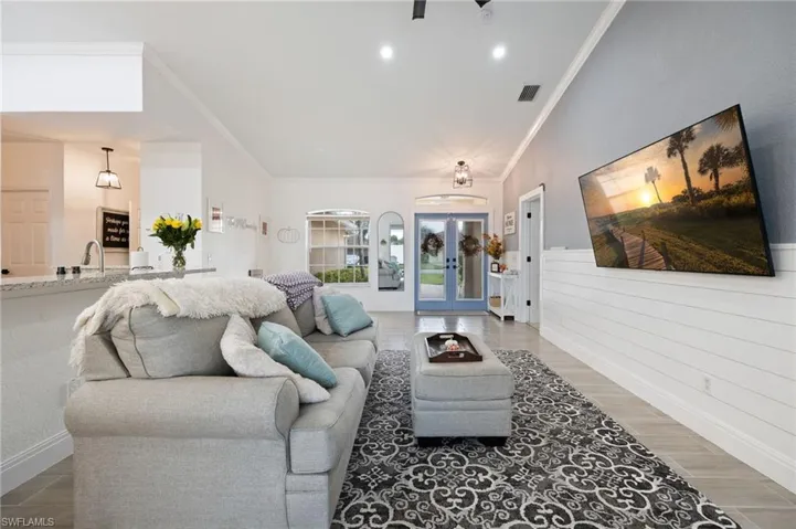 Living room featuring french doors, wood finished floors, and crown molding
