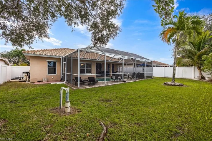 Back of house with a sunroom, a fenced backyard, a patio, and a lanai
