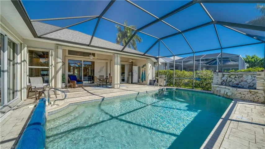 Pool featuring lanai area and waterfall