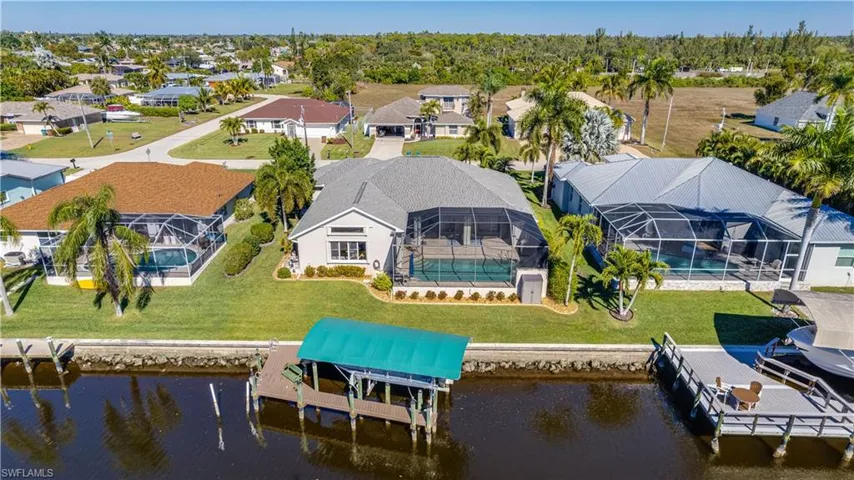 Ariel view of the back of house with covered boat lift and canal