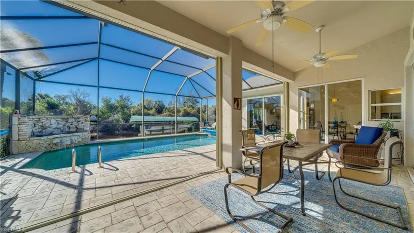 Swimming pool featuring a patio, a sunroom, glass enclosure, and outdoor lounge area