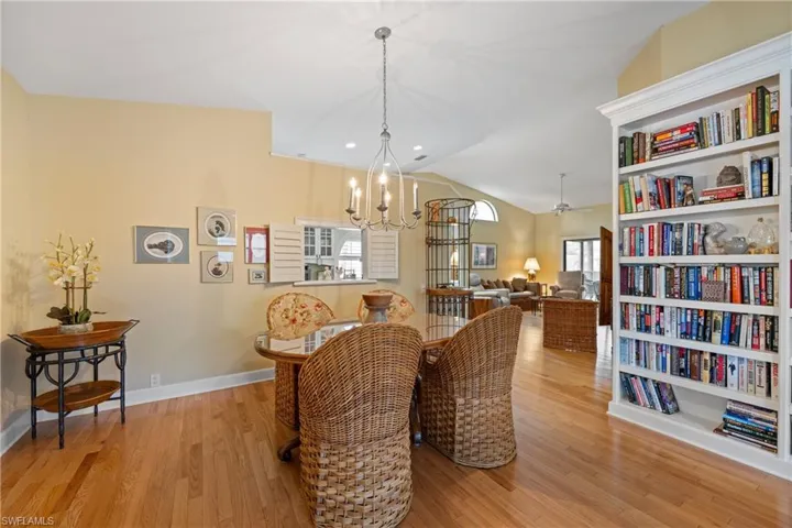 Dining area featuring built in features, a chandelier, light wood-type flooring, and lofted ceiling
